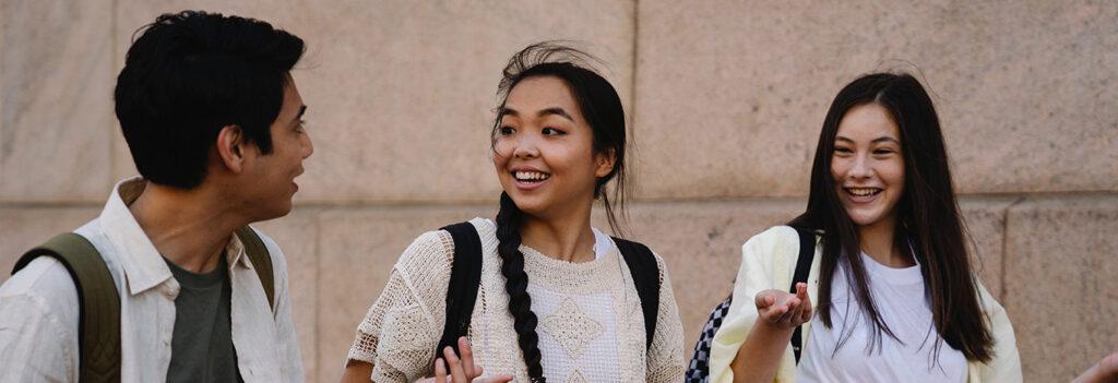 3 estudantes com mochila nas costas conversando sobre as melhores universidades federais do brasil