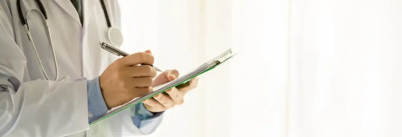 Imagem de um médico escrevendo algo em um prontuário para ilustrar artigo sobre faculdades de medicina em são paulo